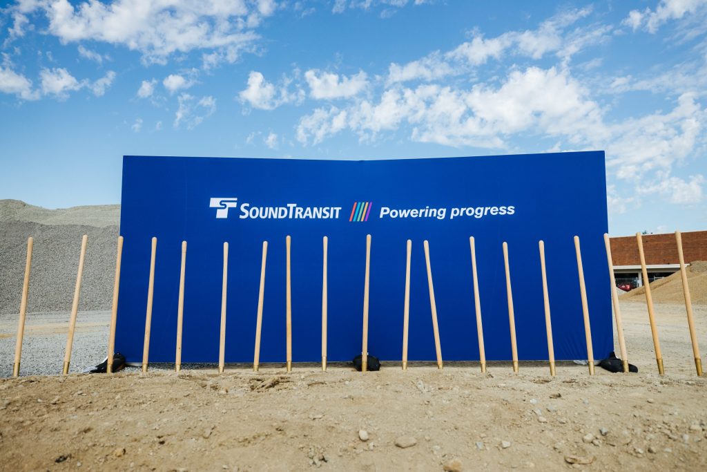 A line of shovels in the ground during a Sound Transit groundbreaking.