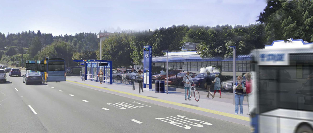 A Stride bus leaves the station in a bus-only lane. Pedestrians, bicyclists, and parked cars are in the station area.